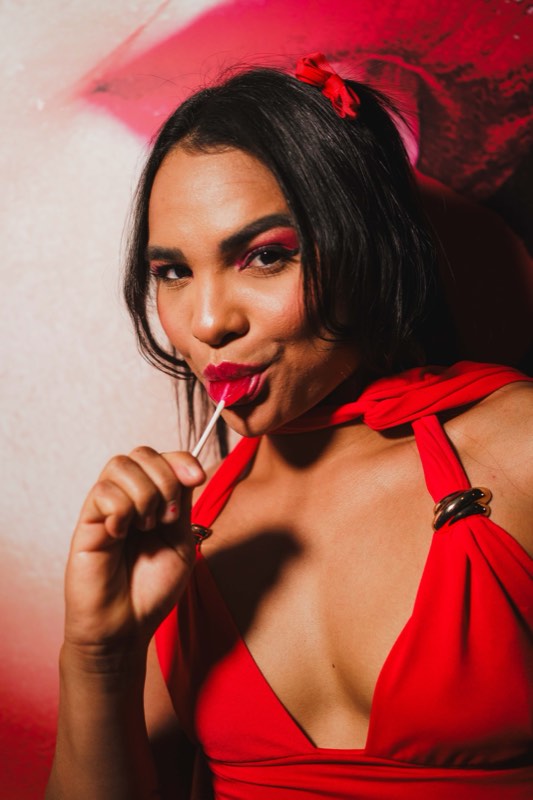 Convidada de vermelho com um chupa-chupa, em luz quente