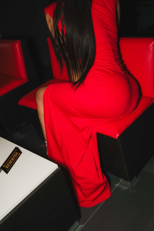 Convidada de vestido vermelho no lounge do bar