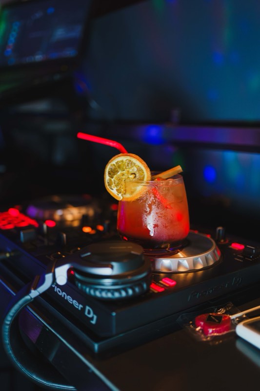 Cocktail pousado sobre a mesa de mistura do DJ