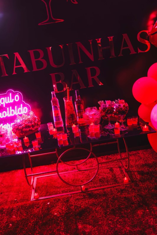 Letreiro «Tabuinhas Bar» com garrafas, velas e balões