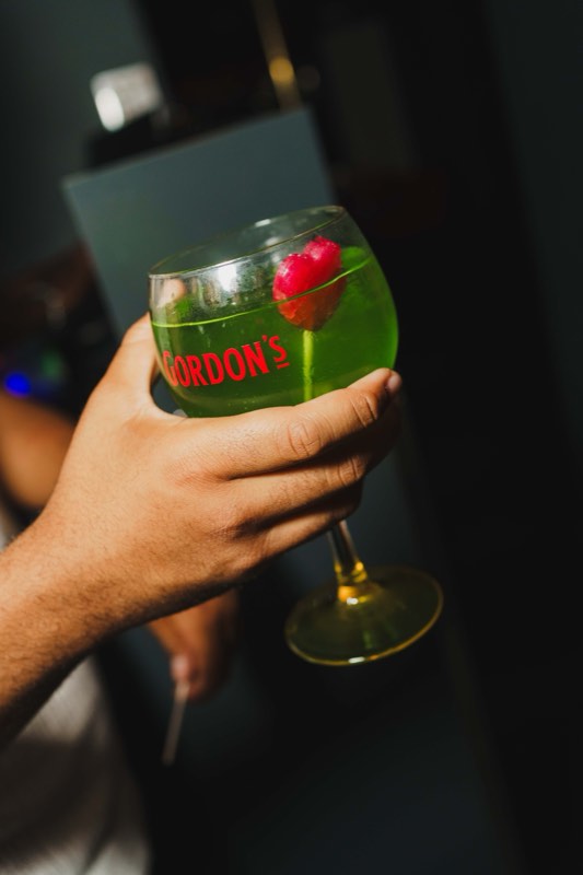 Taça com cocktail verde, em contraluz